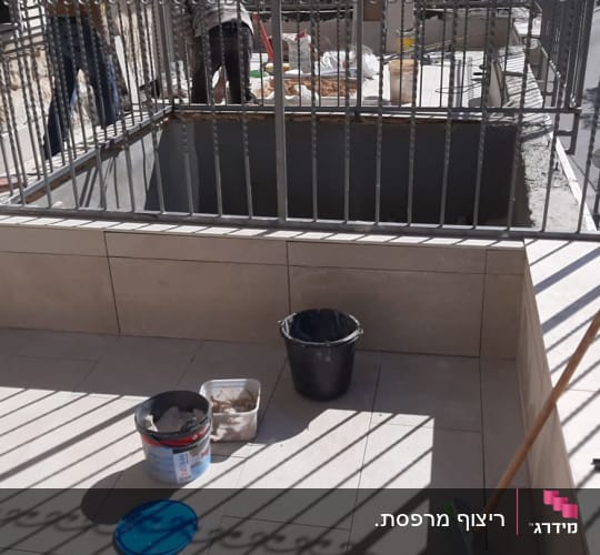 שיפוץ מרפסת עם דלי צבע וכלי עבודה